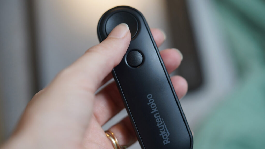 A Kobo e-reader user holds the Kobo Remote in hand.