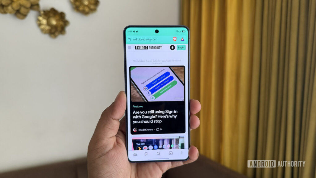 Android phone in hand showing Brave browser