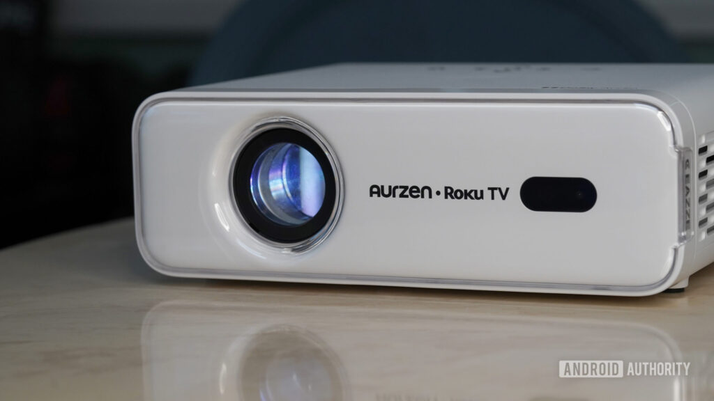 The Aurzen Roku TV EAZZE D1R rests on a stone surface.